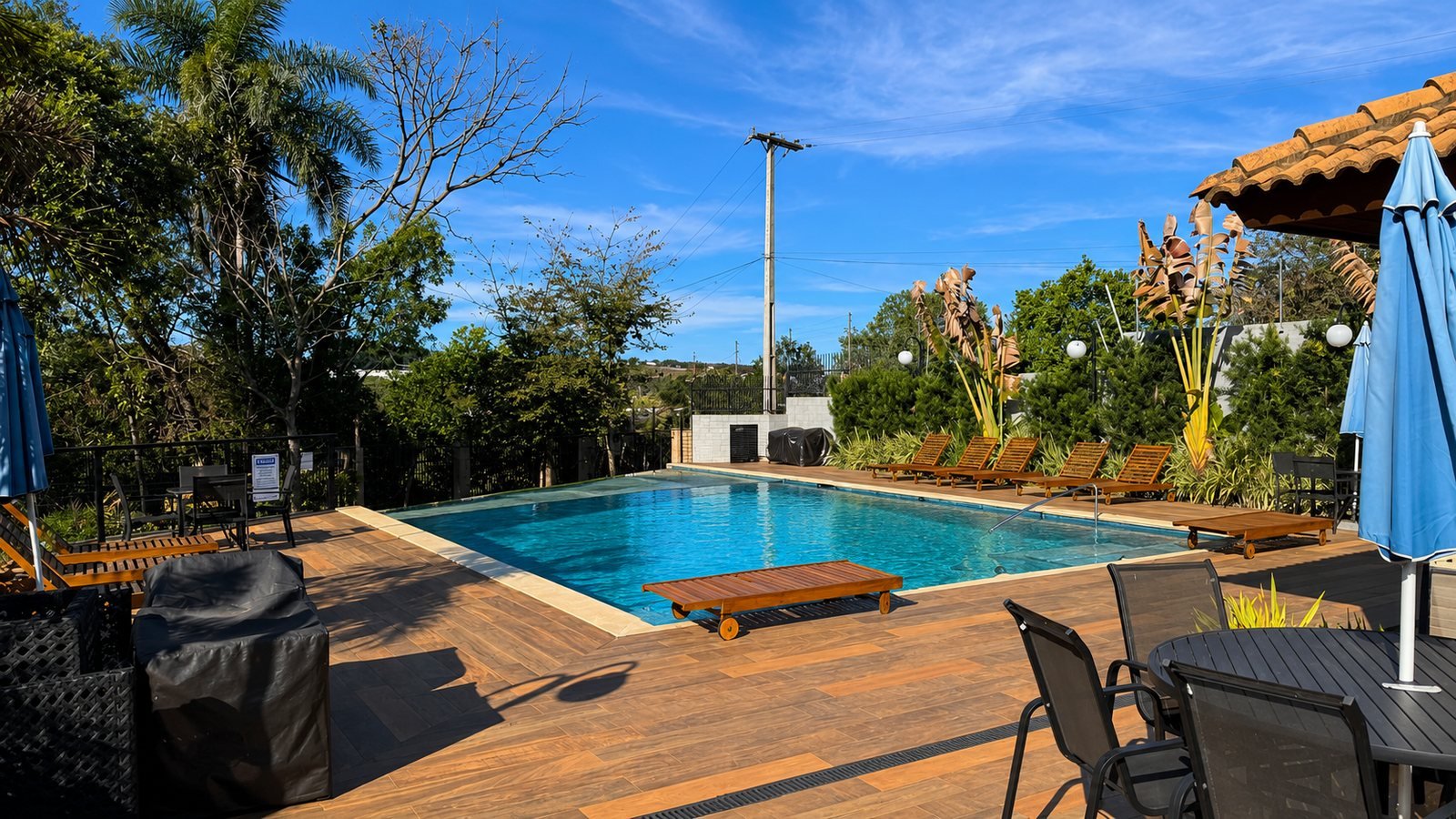 Piscina do condomínio Jardins de Monet, com deck de madeira e espreguiçadeiras