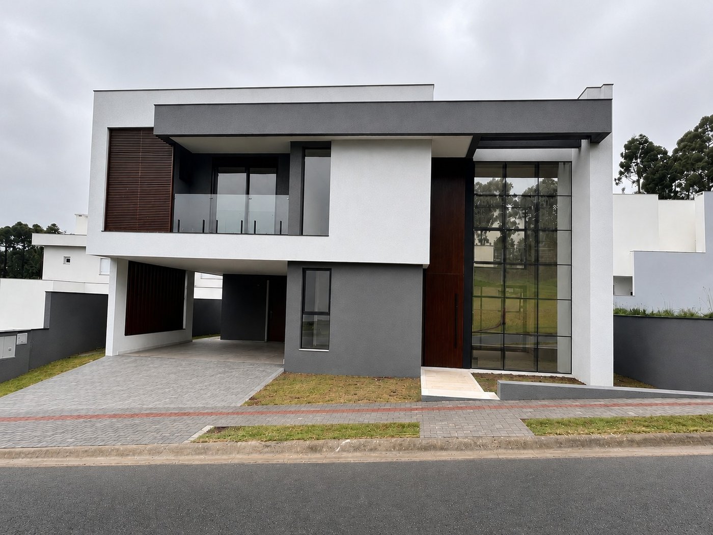 Fachada frontal à luz do dia, destacando o átrio de vidro de pé-direito duplo