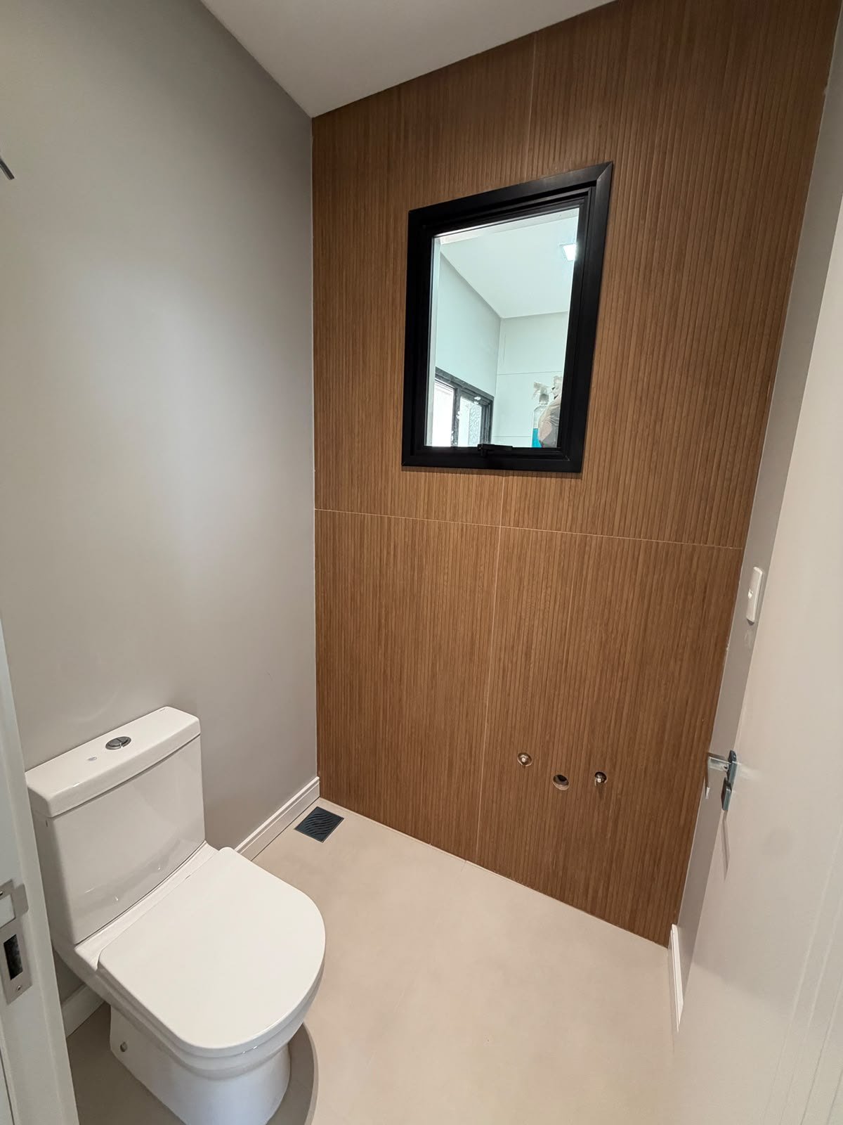 Casa Térrea Alto Padrão — Parque do Som — lavabo com revestimento amadeirado e porta pivotante