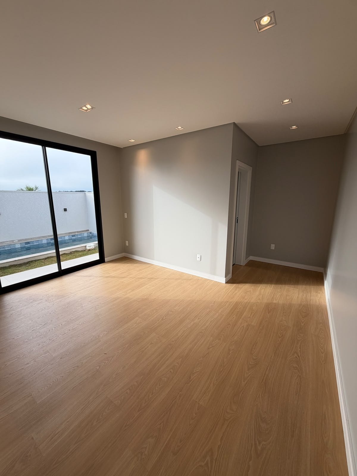 Casa Térrea Alto Padrão — Parque do Som — sala de estar com piso amadeirado e amplo janelão